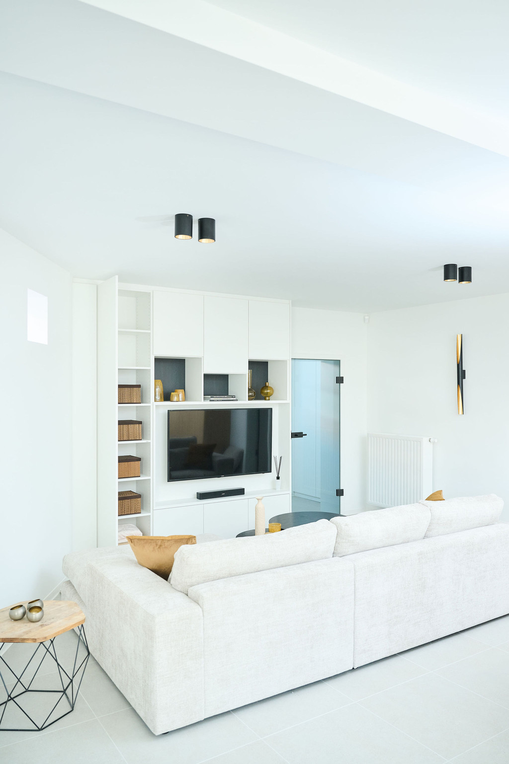 Meuble TV blanc ouvert et fermé sur mesure dans le salon d'Ilse et Frédéric dans l'émission Ons huis/nieuw huis