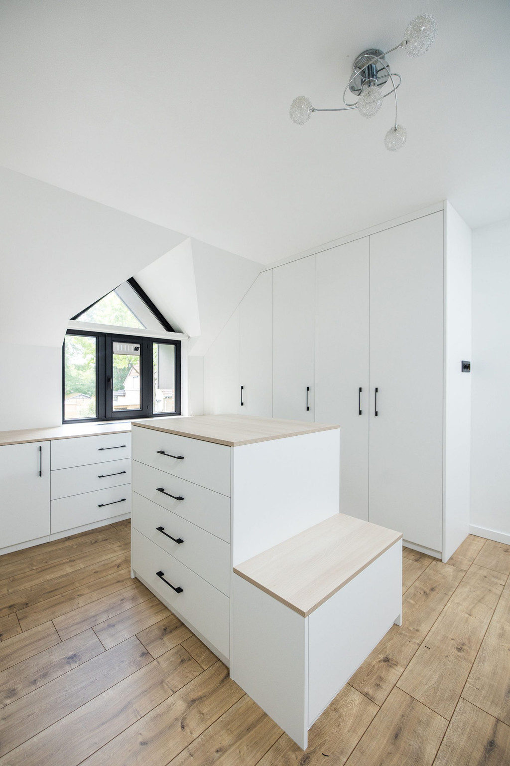 Grand dressing blanc et moderne avec ilot central et assise