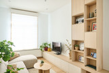 Meuble sur mesure avec niche pour télévision et étagères ouvertes décorées dans un salon clair