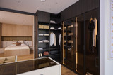 Dressing sur mesure avec portes vitrées, penderie et éclairage LED intégré en bois foncé dans un showroom