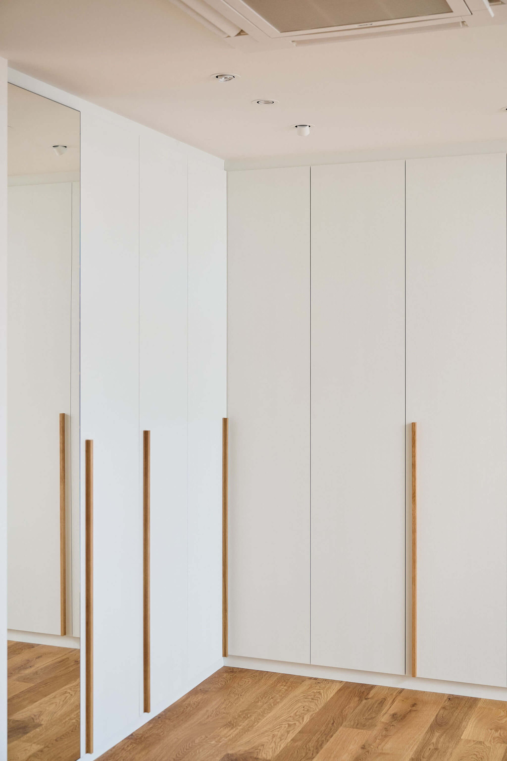 Gesloten dressing in L-vorm met spiegeldeur