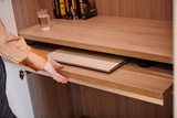 Bureau sur mesure avec tablette escamotable, un ordinateur portable glissé sous la surface de travail, offrant un espace pratique et épuré.