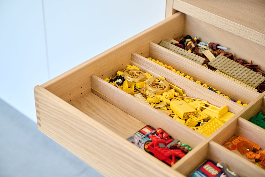 Détail d'un tiroir sur mesure avec rangement pour jouets et blocs de construction colorés.