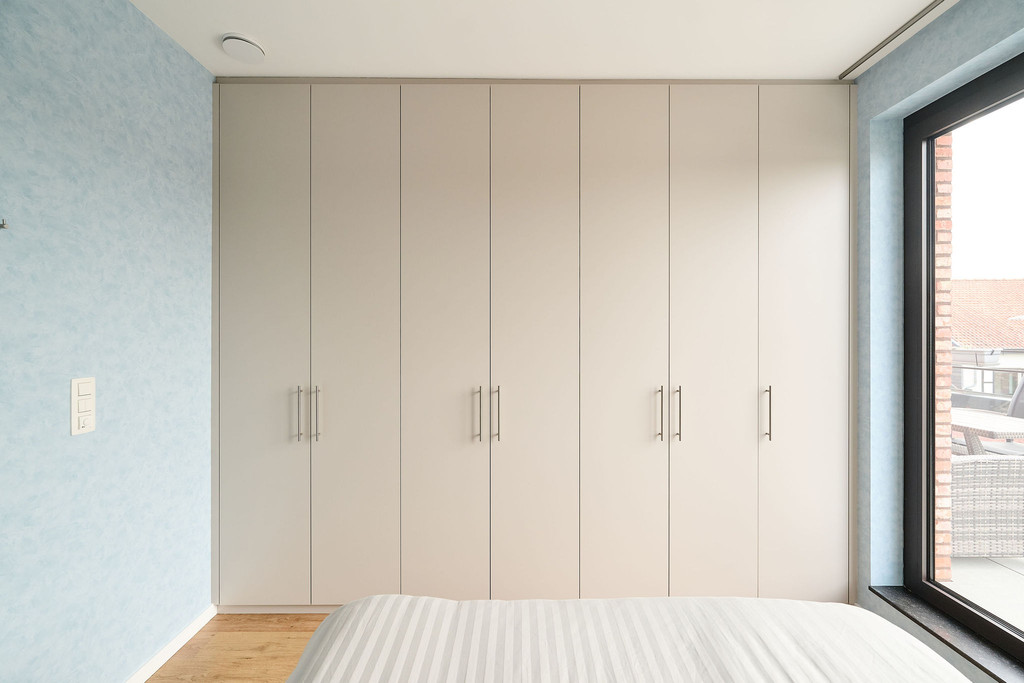 Dressing sur mesure pleine hauteur avec portes en tons clairs et poignées élégantes, offrant un rangement maximal et un design épuré, réalisé par Camber
