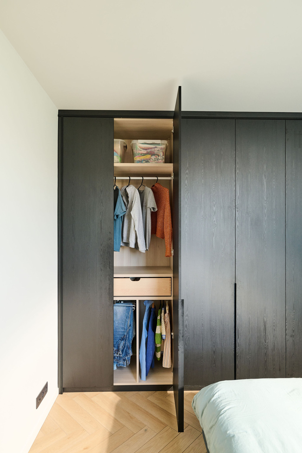 Armoire sur mesure en bois foncé avec penderie, tiroir central et espaces de rangement ouverts
