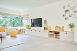 Meuble bas de salon sur mesure avec rangement ouvert et fermé, accompagné de décorations modernes et plantes.