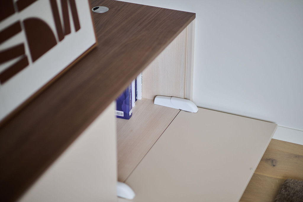 Détail du meuble télé sur mesure avec sécurité enfant sur la porte dans salon moderne
