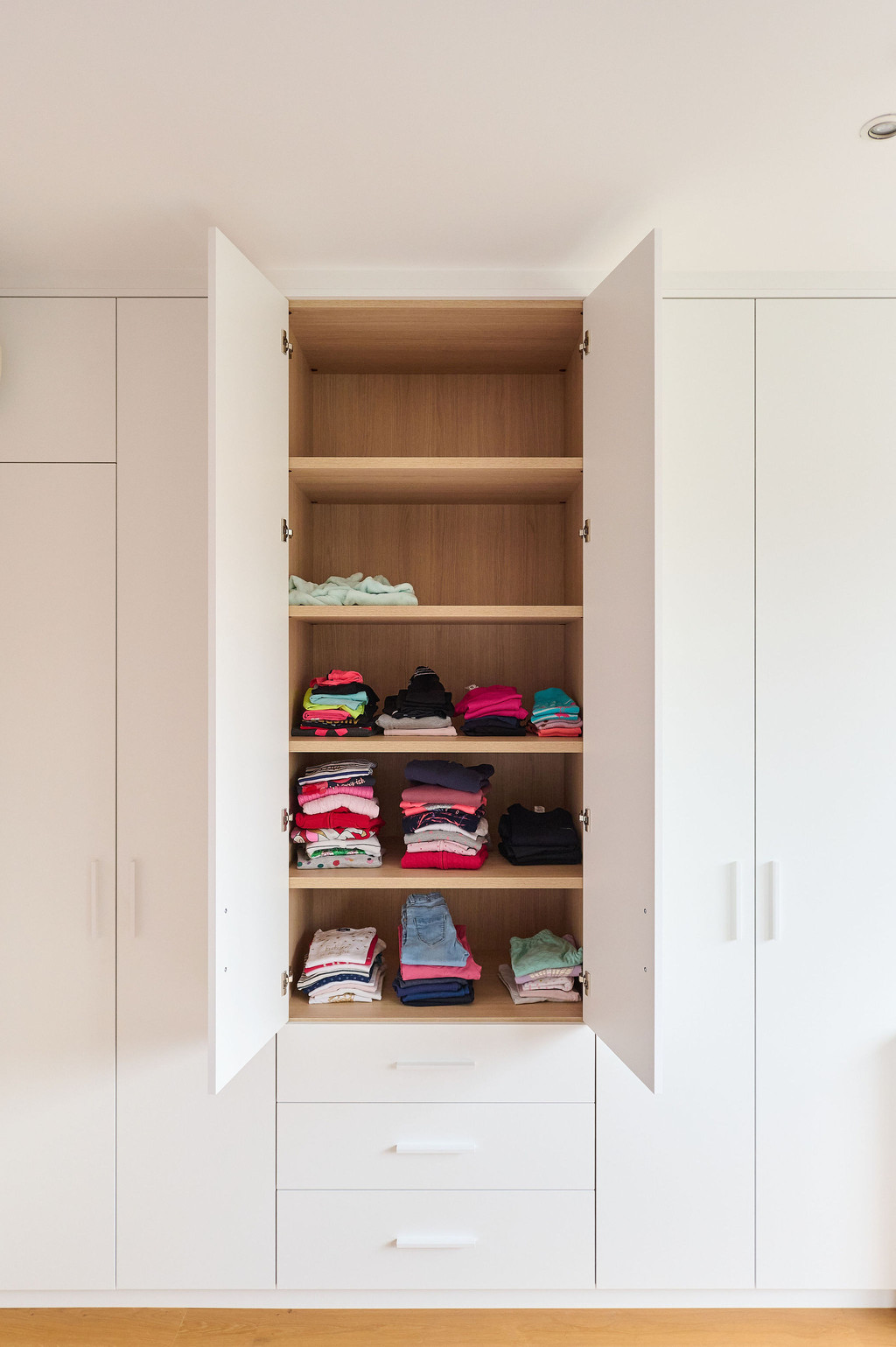 Dressing fermé avec étagères en bois dans la chambre d'enfant d'Isaline