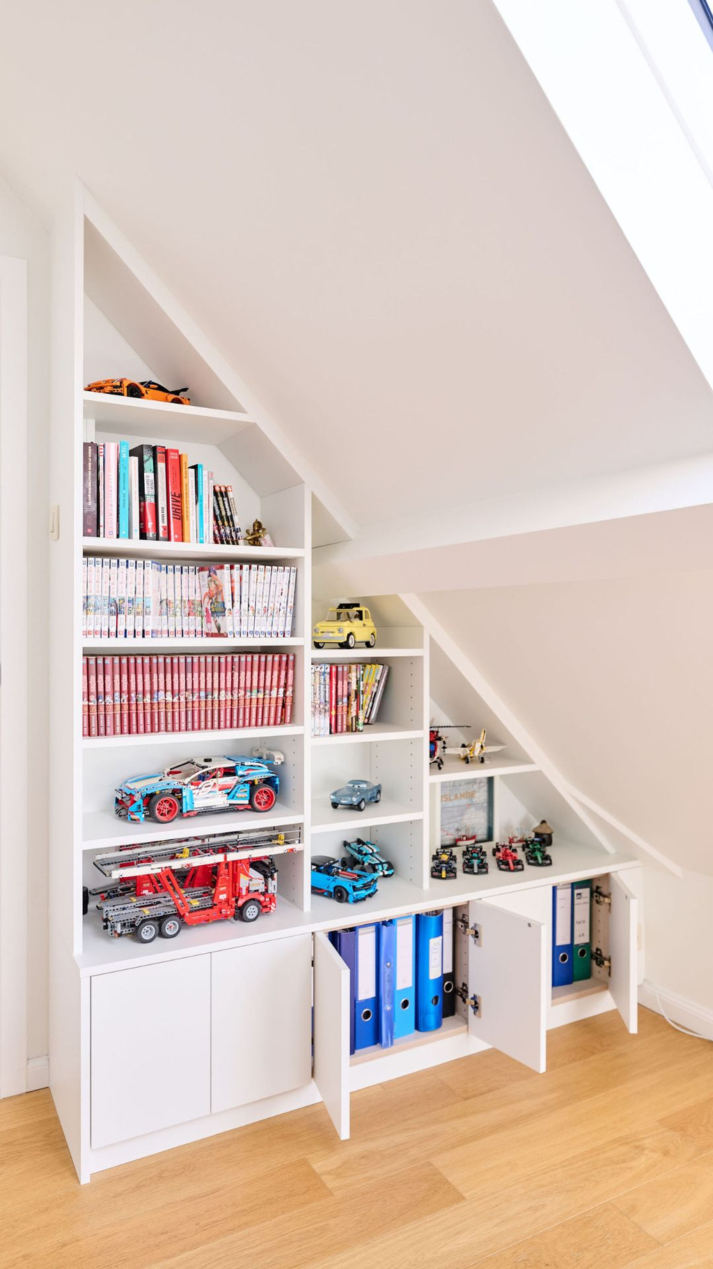 Placard sur mesure sous pente avec niches ouvertes, rangements fermés et espace organisé dans une chambre d’enfant