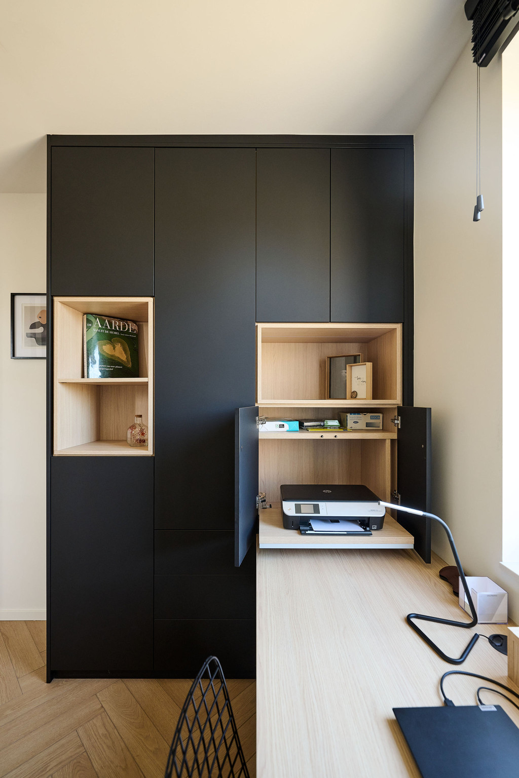 Armoire noire sur mesure avec niches en bois et plateau coulissant pour imprimante dans un bureau à domicile