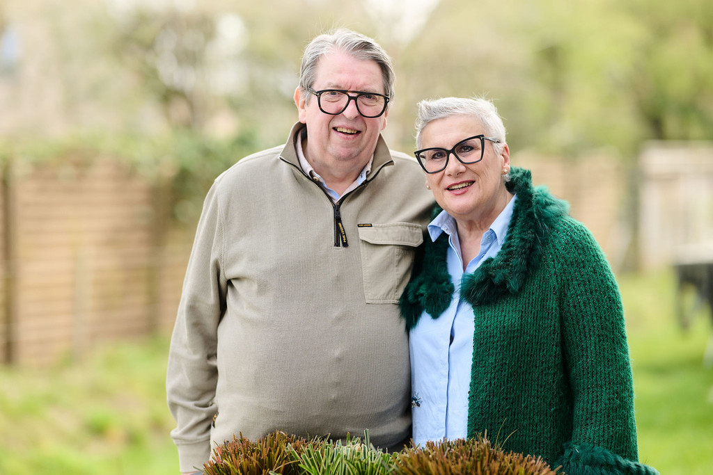 Couple de clients souriants à l’extérieur, illustrant la satisfaction après la réalisation d’un projet d’aménagement sur mesure par Camber