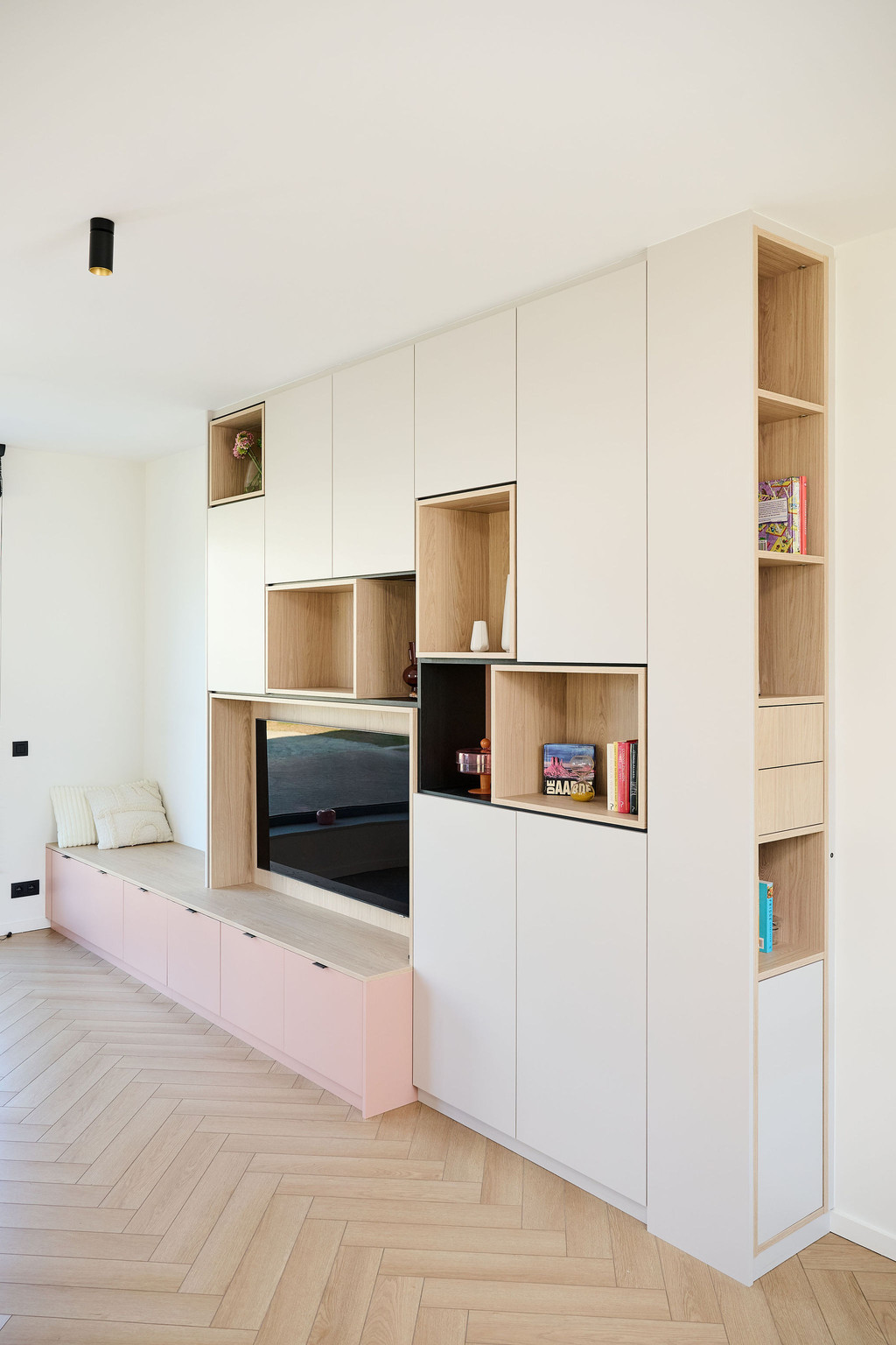 Meuble mural sur mesure avec assise, niches ouvertes en bois et espace TV intégré dans un salon lumineux