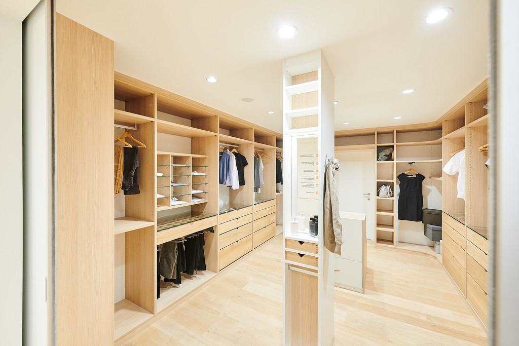 Dressing sur mesure en bois clair avec tiroirs et étagères spacieux