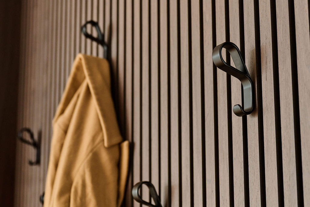 Vestiaire op maat met kapstokjes op panelen met houten latjes in donkerhout