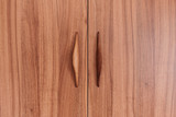 Portes d’armoire en bois avec poignées sculptées intégrées pour une finition naturelle et élégante.
