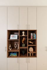 Placard sur mesure avec niches ouvertes en finition bois pour exposer des objets décoratifs, combiné à des rangements fermés pour un intérieur harmonieux, réalisé par Camber