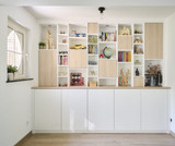 Ce mur d’armoires sur mesure associe niches ouvertes et modules fermés. Une solution élégante pour exposer vos objets tout en gagnant du rangement.