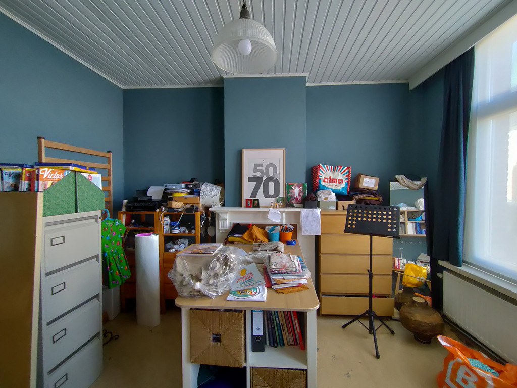 Chambre d’amis d’Els et Kevin avant le relooking Camber, avec une organisation désordonnée, des meubles indépendants, du matériel de loisirs et de couture, et un manque de rangement structuré