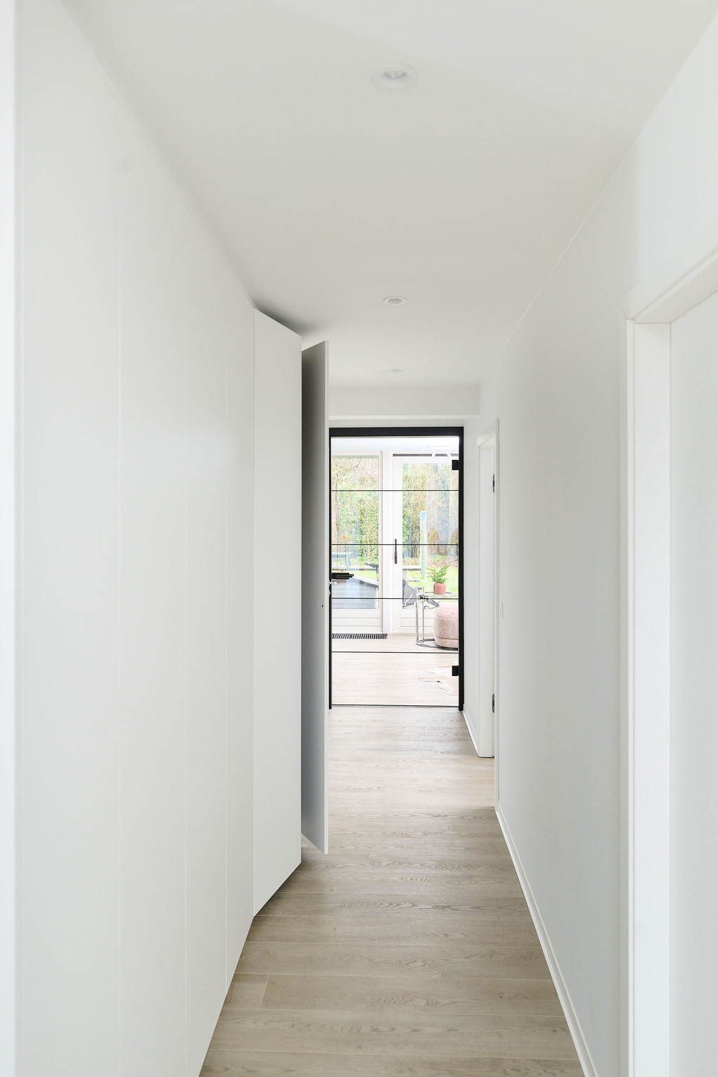 Vestiaire blanc sur mesure dans le hall d'entrée de Elyne et Lorenz à Pulderbos