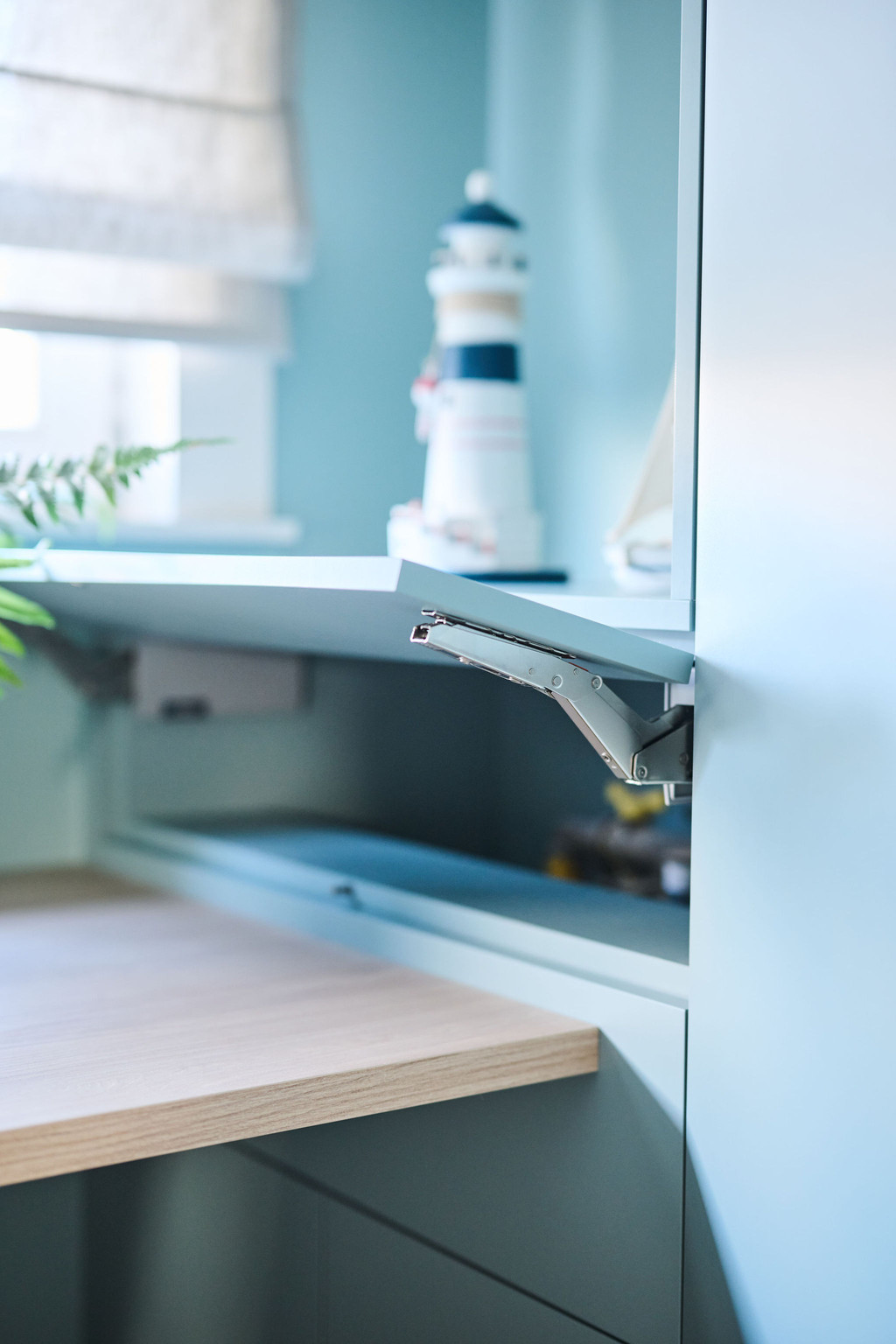 Open klepkast met scharnier in blauw bureau boven werkblad met houten afwerking en decoratie