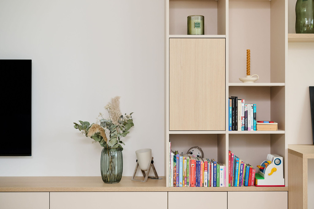 Meuble TV sur mesure avec niches ouvertes, étagères pour livres, vase décoratif et objets de décoration moderne.