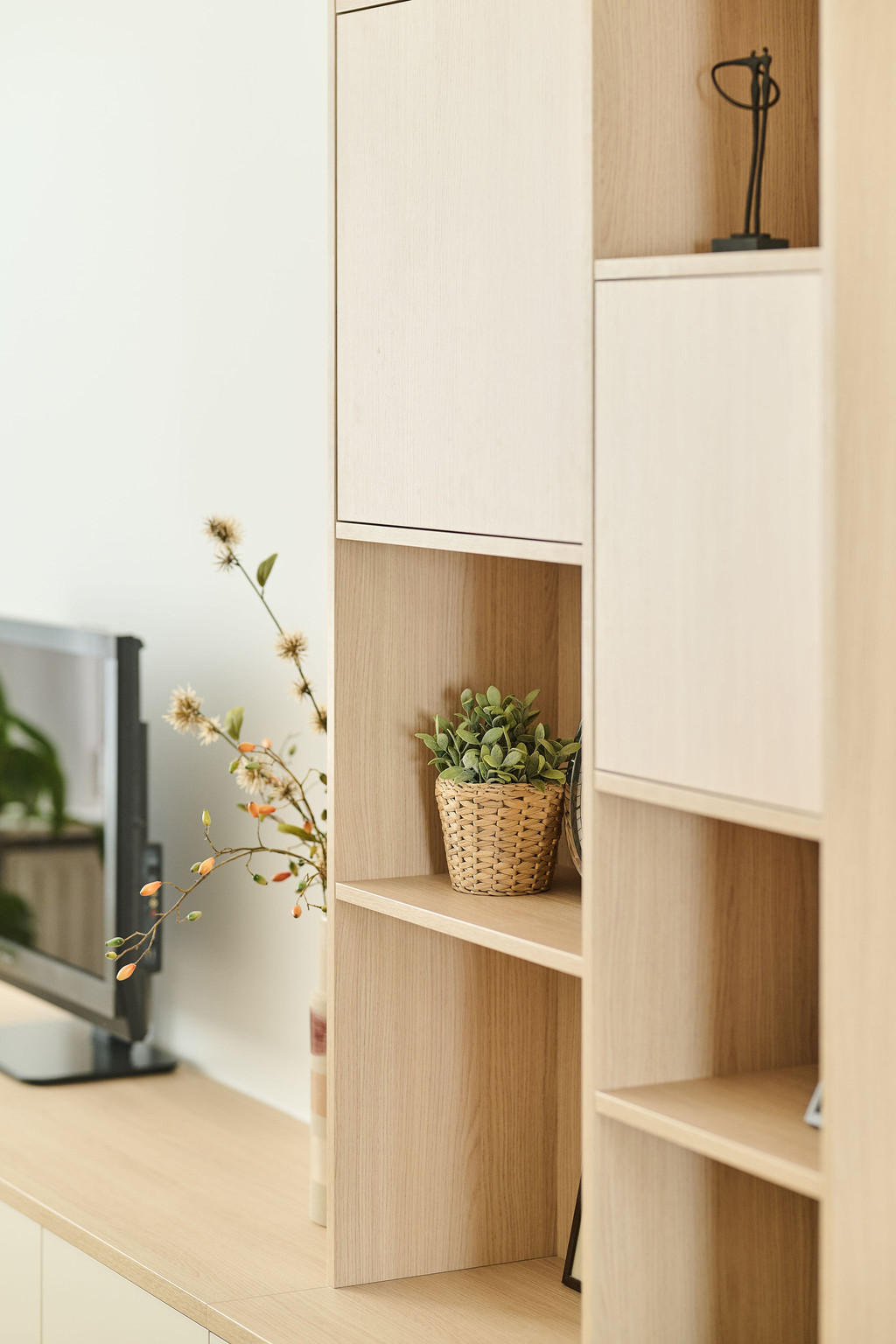 Meuble sur mesure clair avec niches ouvertes et objets déco dans un salon