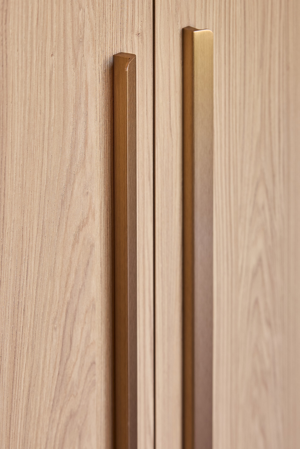 Detail van geïntegreerde handgrepen in houten kastdeuren van een maatkast, met een strakke en elegante afwerking, gerealiseerd door Camber