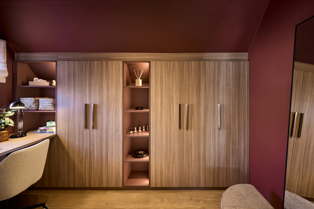 Dressing sur mesure avec portes en bois, niche ouverte et éclairage intégré dans des tons chaleureux