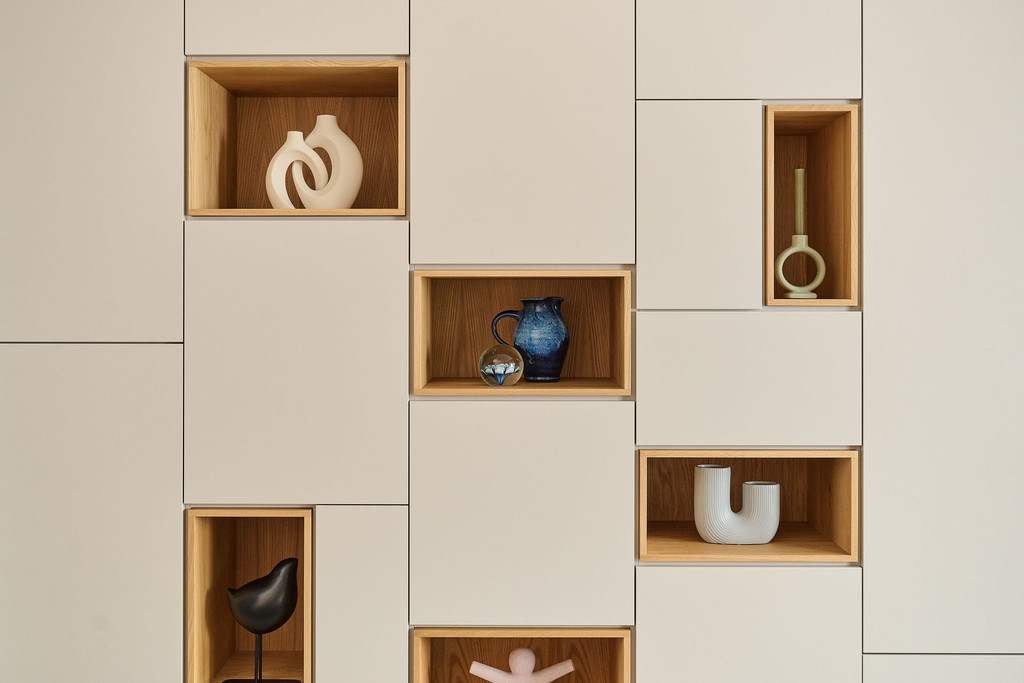 Détail d’un meuble sur mesure avec niches ouvertes en finition bois et objets décoratifs, apportant chaleur et caractère à l’intérieur, réalisé par Camber
