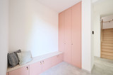 Hall avec armoires sur mesure roses, banc avec coussins et rangements hauts
