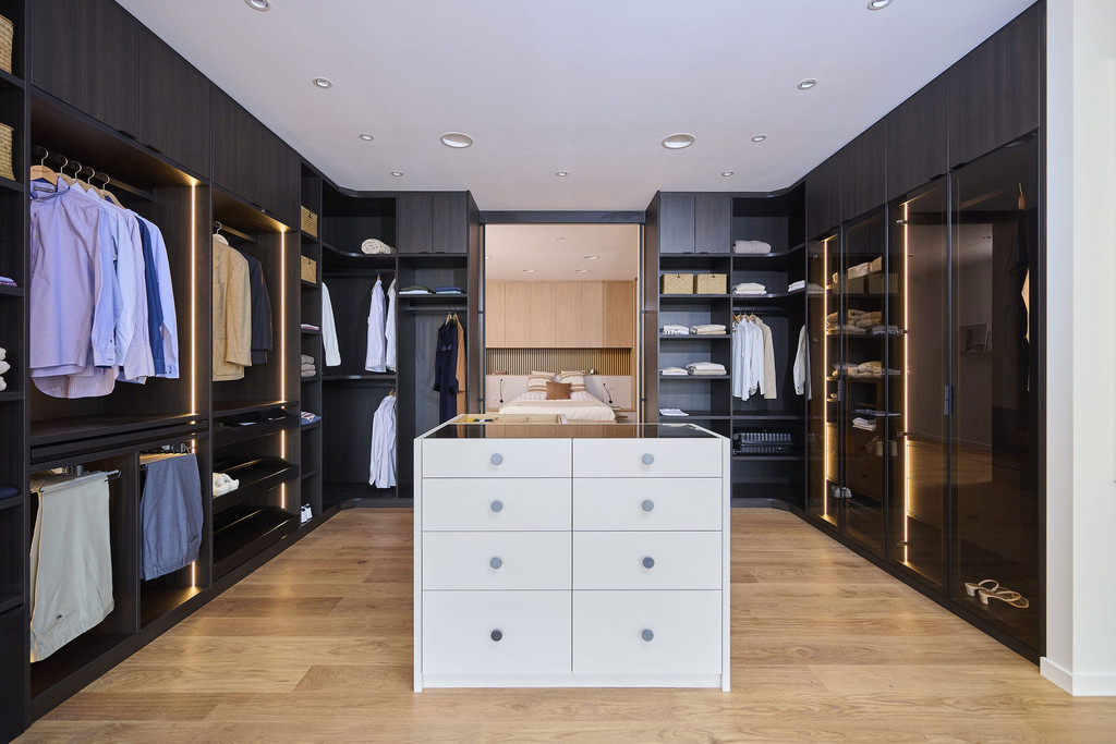 Dressing spacieux sur mesure avec îlot central, penderies et niches ouvertes dans un showroom