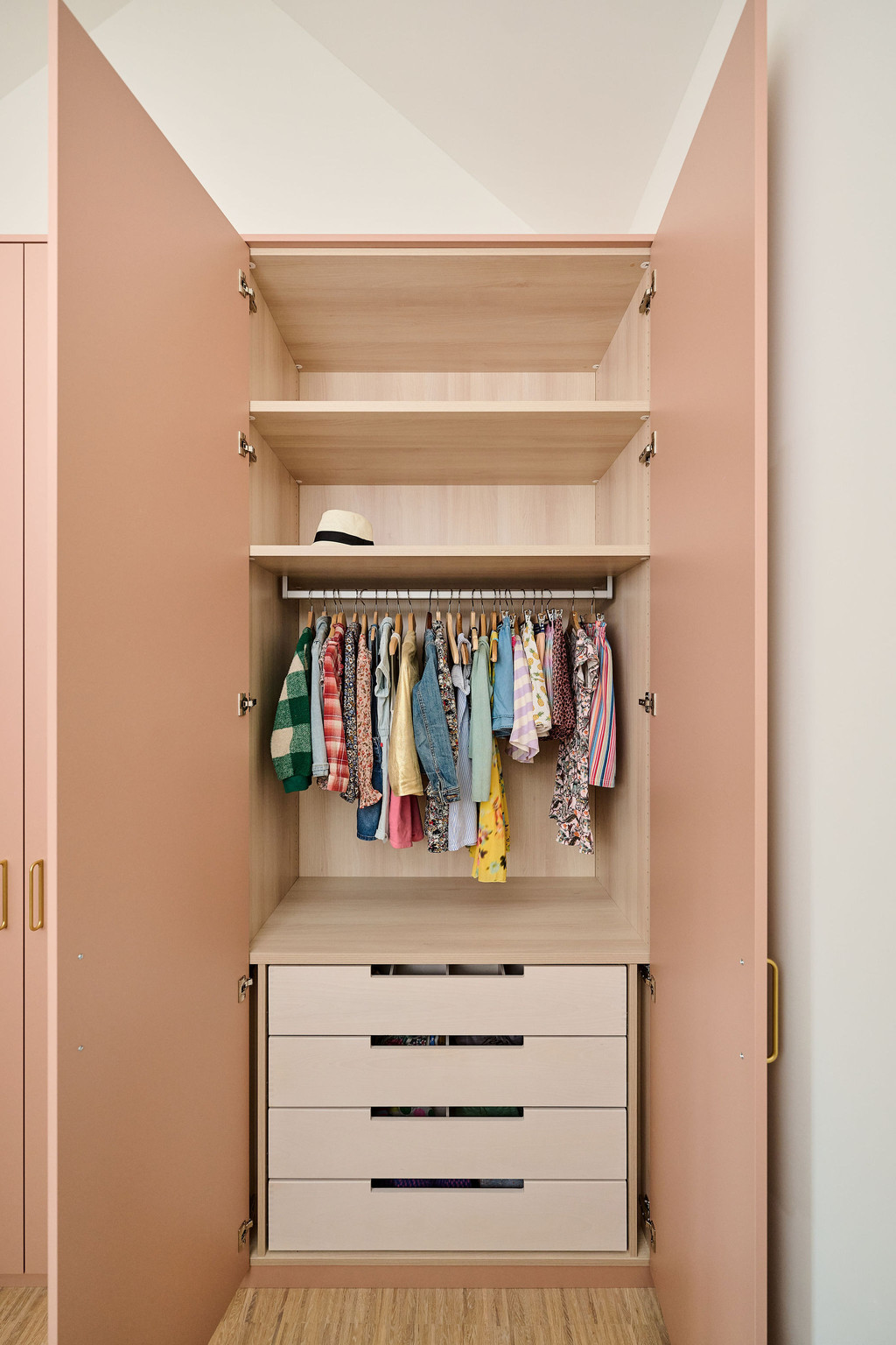 Dressing sur mesure rose dans une chambre d'enfant avec tiroir et penderie