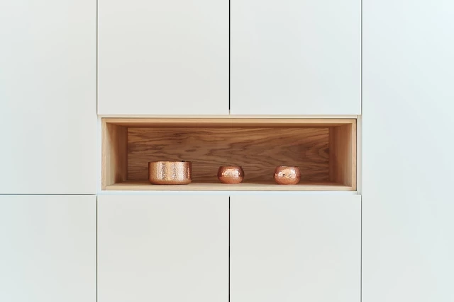 Op maat gemaakte kast met open houten nis en decoratieve accessoires.