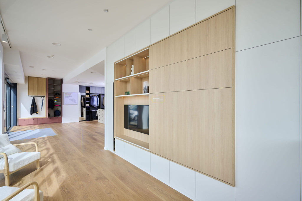Meuble TV sur mesure avec niches ouvertes et rangements fermés dans un showroom moderne