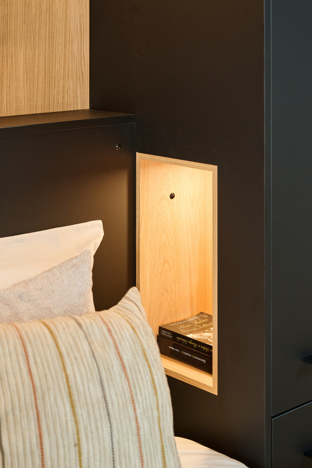 Niche ouverte intégré dans le pont de lit de la chambre à coucher, exposée dans le showroom de Gosselies