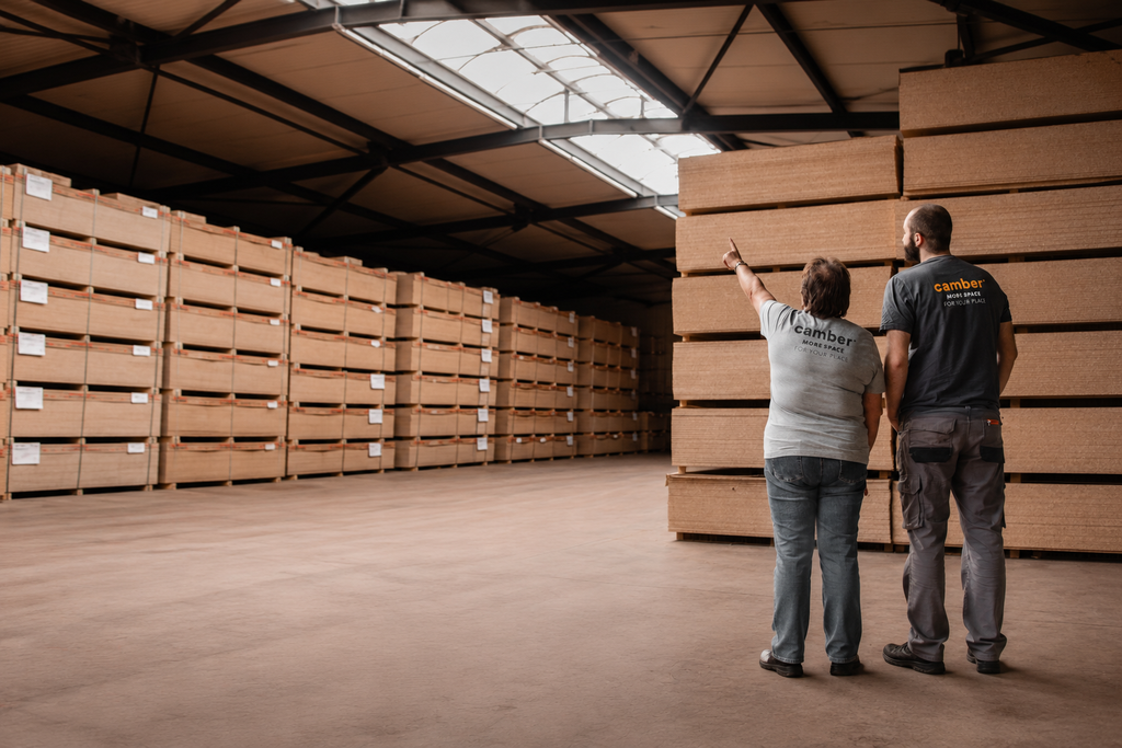 Collaborateurs Camber dans un entrepôt de panneaux de bois certifiés, illustrant l'engagement de l'entreprise en faveur de la durabilité et d'une gestion responsable des matériaux.