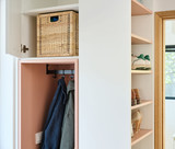 Detail van een Camber vestiaire op maat met open nis voor jassen, geïntegreerde jashaken, bovenkast met opbergbak en aansluitend open schoenenrek in een lichte afwerking