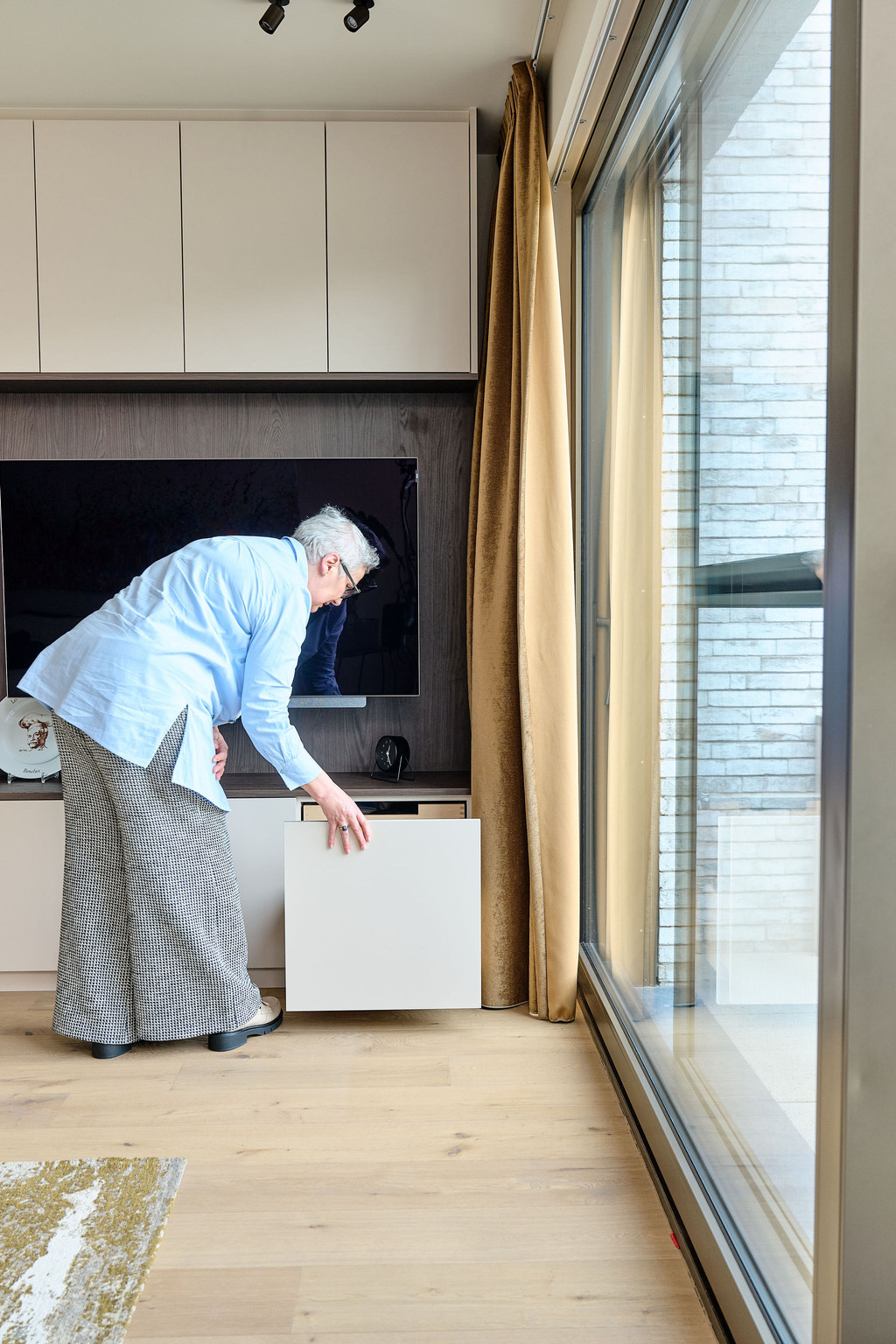 Meuble TV sur mesure avec compartiment de rangement dissimulé, illustrant une solution pratique et discrète pour optimiser l’espace dans le salon, réalisé par Camber