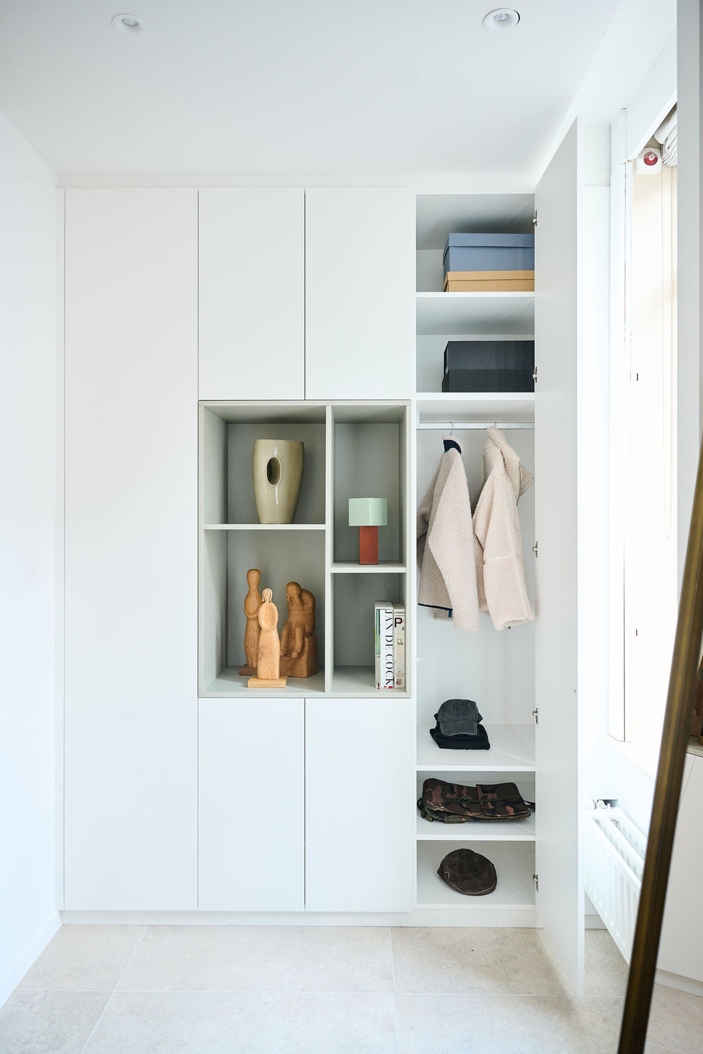 Vestiaire blanche entièrement ouverte avec niches décoratives étagères manteaux sac à main et chaussures