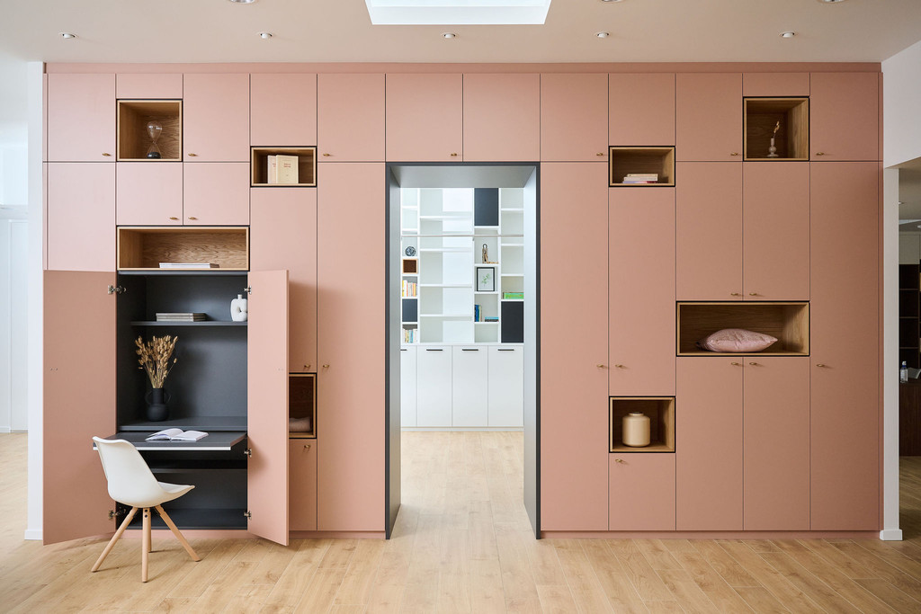 Roze multifunctionele ingebouwde boekenkast op maat met kasten en open nissen en dek over deur in Waver