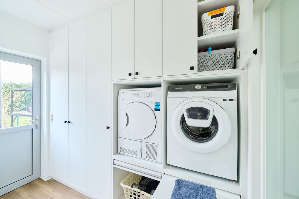 buanderie blanche sur mesure avec espace pour machine à laver et sèche-linge
