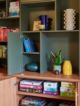 Groene wandkast met open en gesloten vakken en accessoires