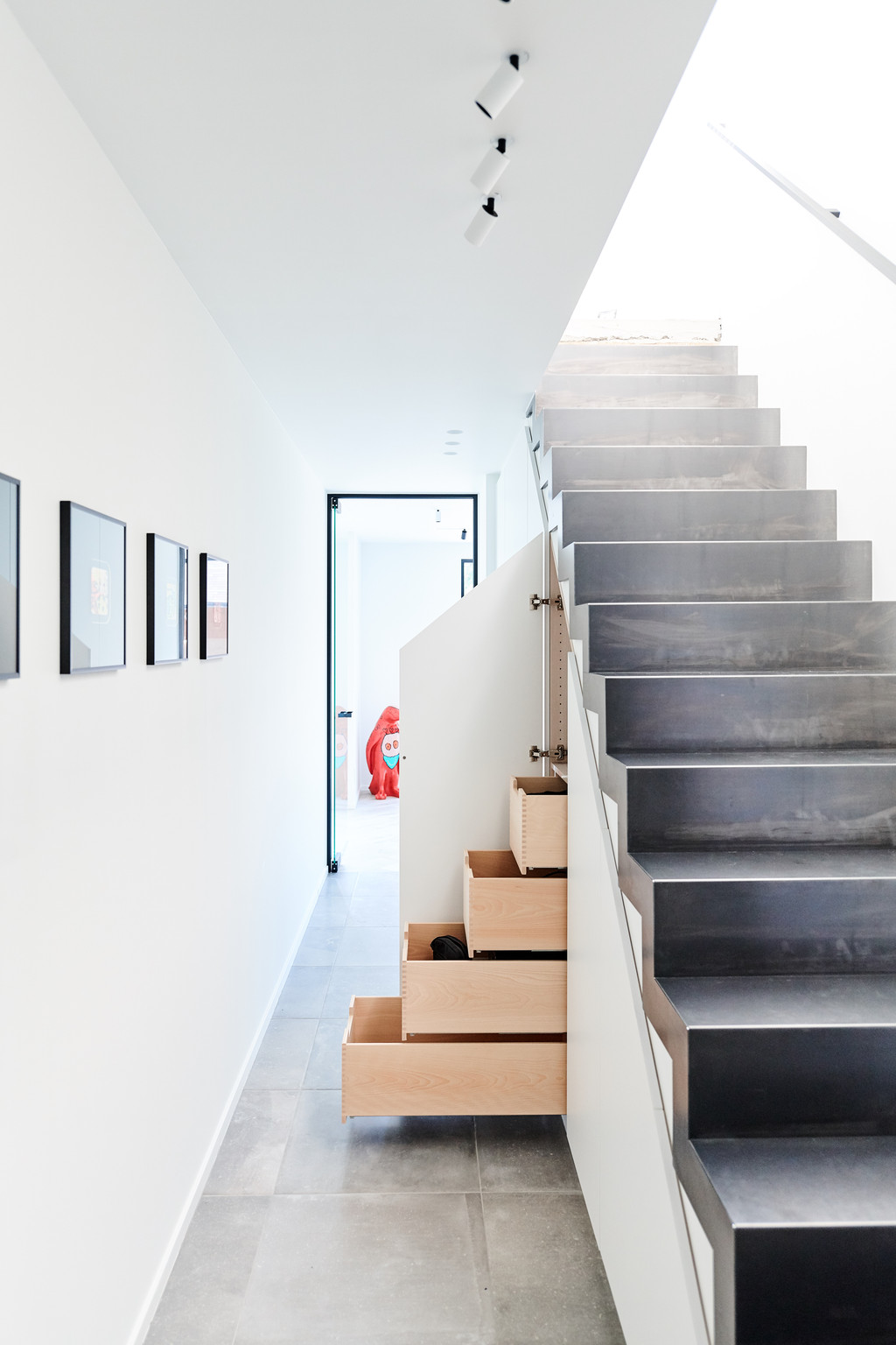 Modern trappenhuis met ingebouwde opbergkasten onder de trap voor extra bergruimte.