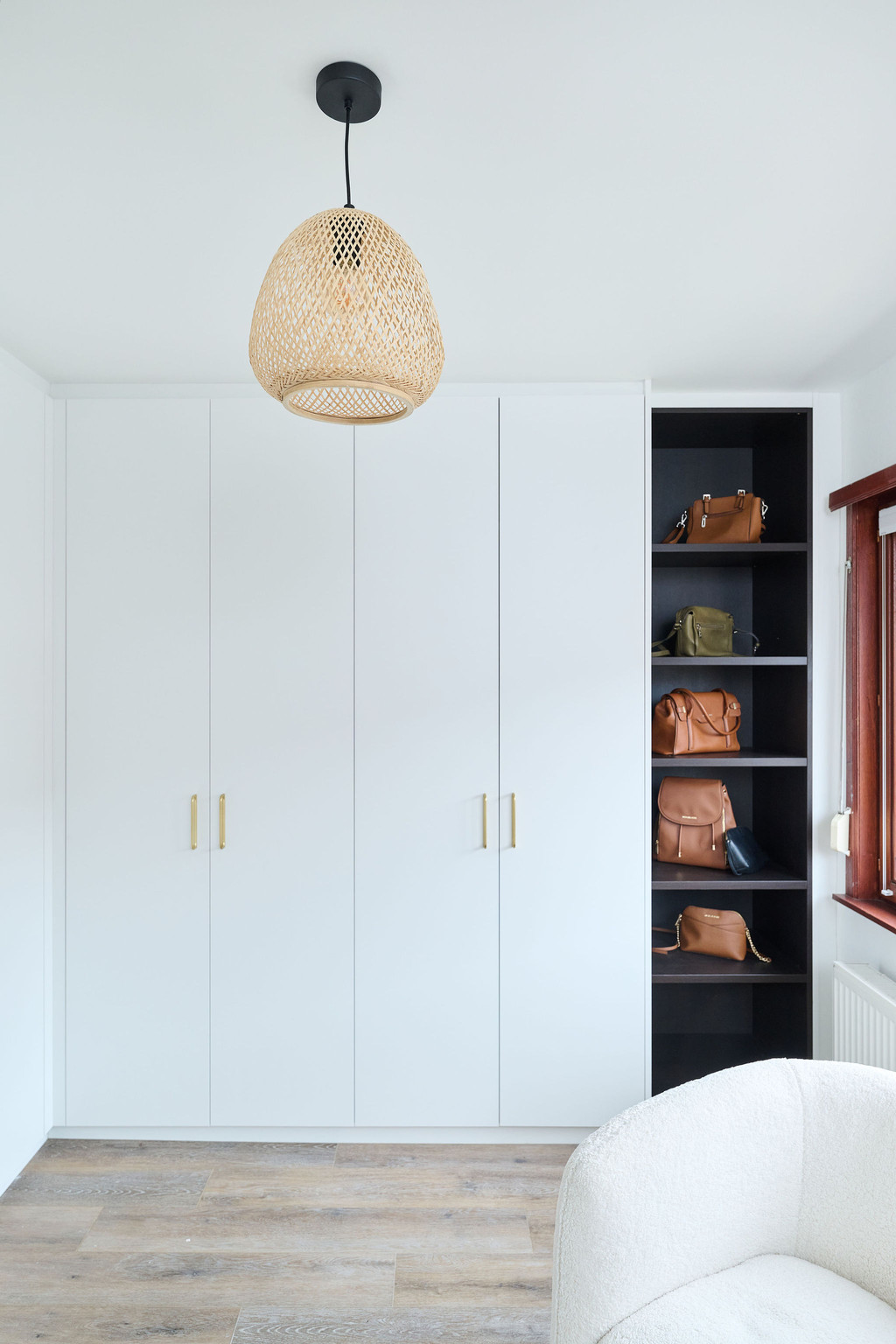Op maat gemaakte witte dressing met gouden handgrepen, gecombineerd met open zwarte vakken voor het organiseren van handtassen.
