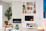 Meuble mural blanc sur mesure avec TV intégrée niches déco abattant ouvert et foyer dans un intérieur moderne