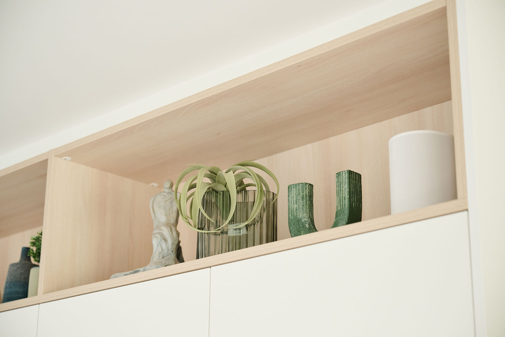 Niche avec vases verts et sculpture dans un meuble mural blanc sur mesure