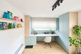 Licht bureau op maat met blauwe kasten houten accenten en speelse wandplanken met kinderboeken