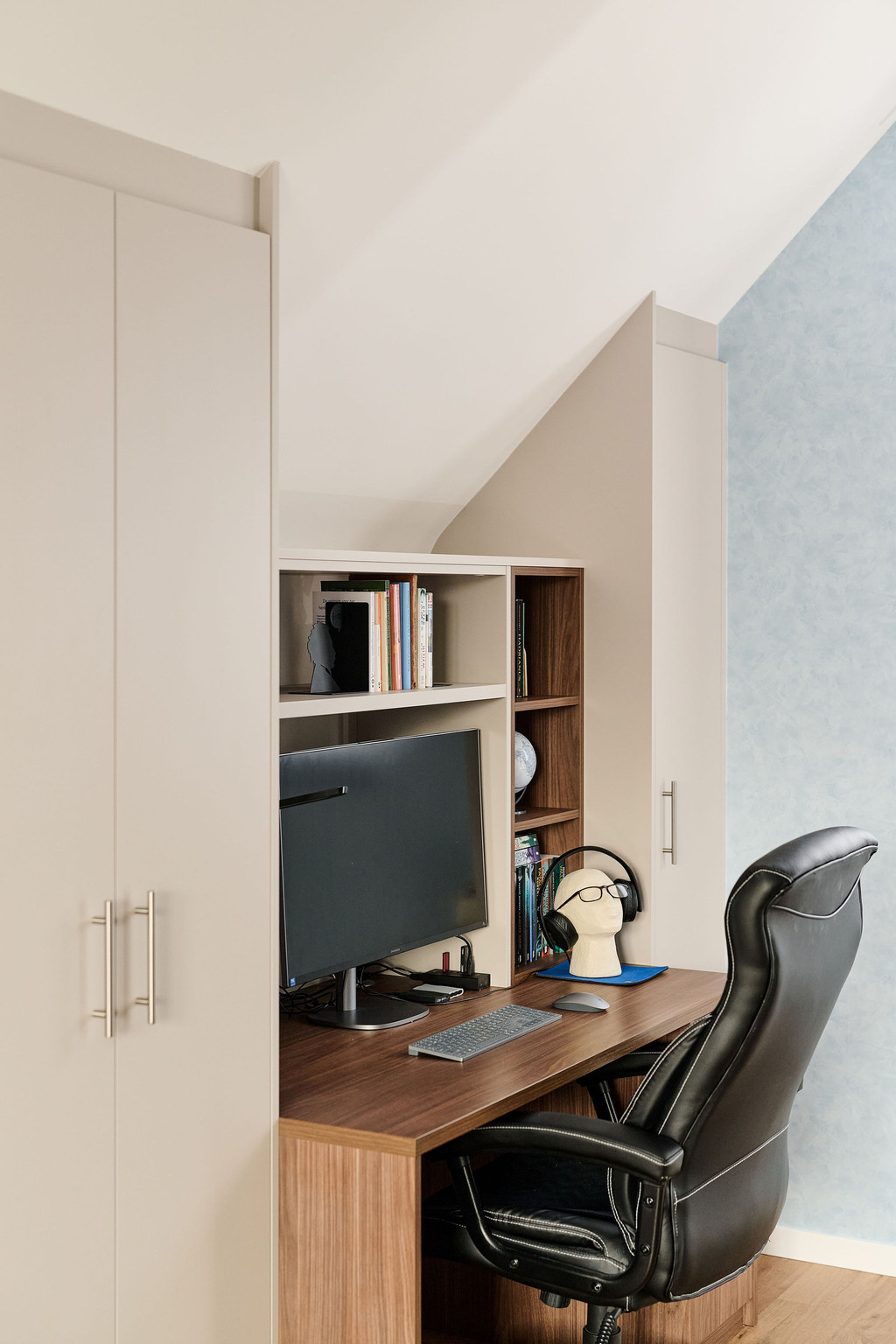 Bureau sur mesure en bois naturel avec étagères intégrées et espace pour écran, combiné à des armoires en tons clairs pour un espace de travail fonctionnel, réalisé par Camber