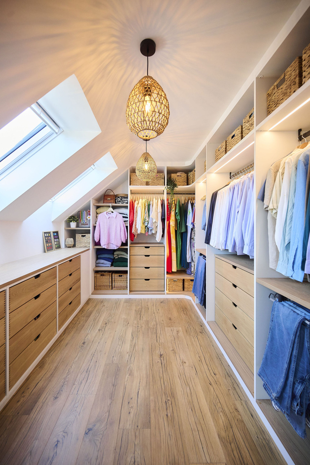 Dressing op maat onder een schuin dak met hangruimte, lades en open legplanken, voor een optimale benutting van de ruimte, gerealiseerd door Camber