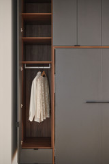 Opklapbed op maat met geïntegreerde kast en hanggedeelte voor kleding in een moderne slaapkamer